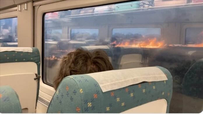 During a severe heatwave, a passenger train in Spain is encircled by a wildfire.